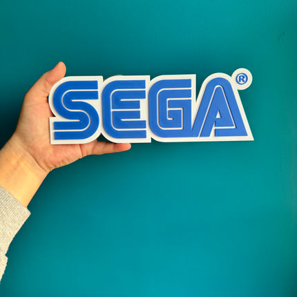 Plaque 3D SEGA imprimée en PLA bleu et blanc, 24 cm de large.

